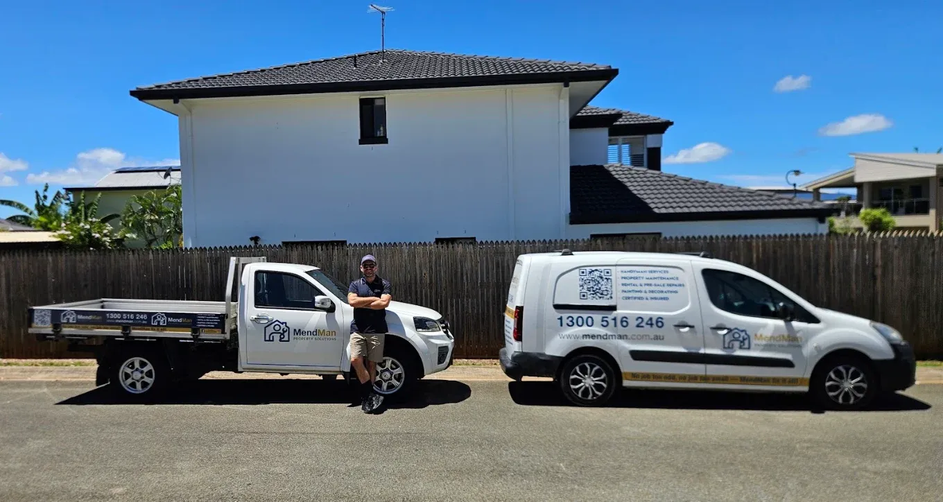 MendMan handyman beside the branded work truck and van