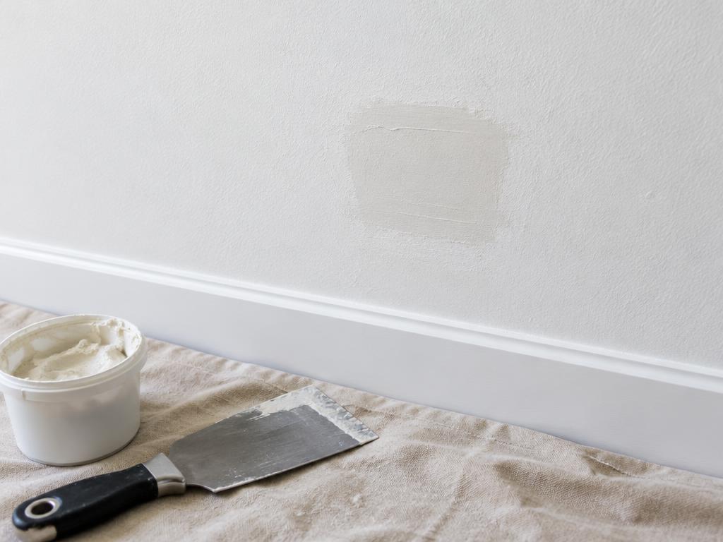 Illustrative image of a small wall patch with plastering tools